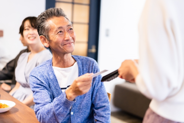 飲食店でクレジットカードで支払う男性