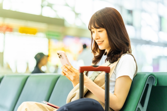 スマートフォンで旅費を確認する女性