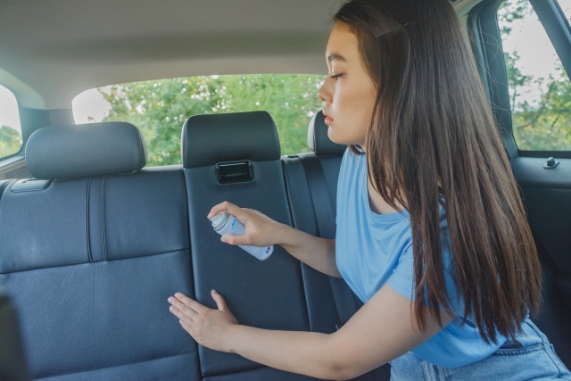 自動車のシートに消臭剤を吹きかける