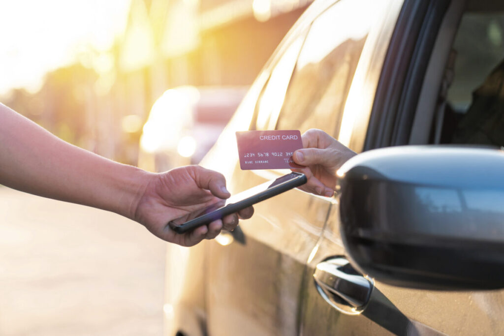 自動車のなかから手を出して、クレジットカードで支払う