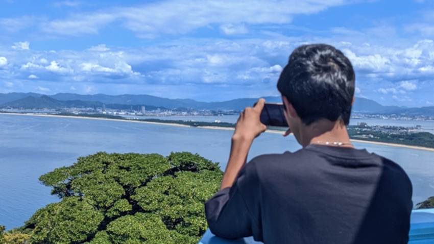 旅先で景色を撮影している男性