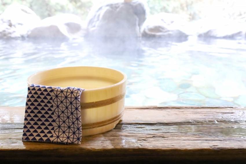 温泉と手拭いが掛けられた桶