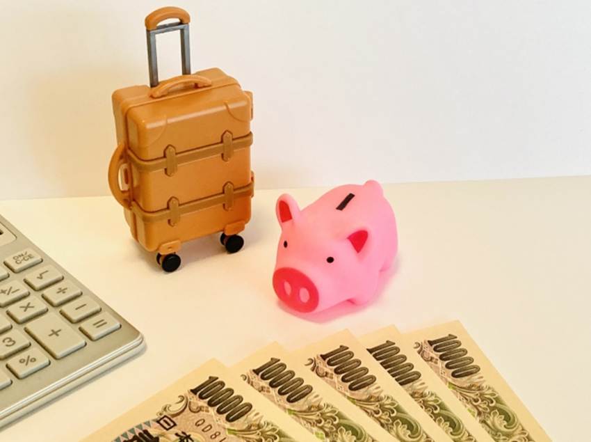 旅行用キャリーバッグと貯金箱のミニチュア、10,000円札と電卓