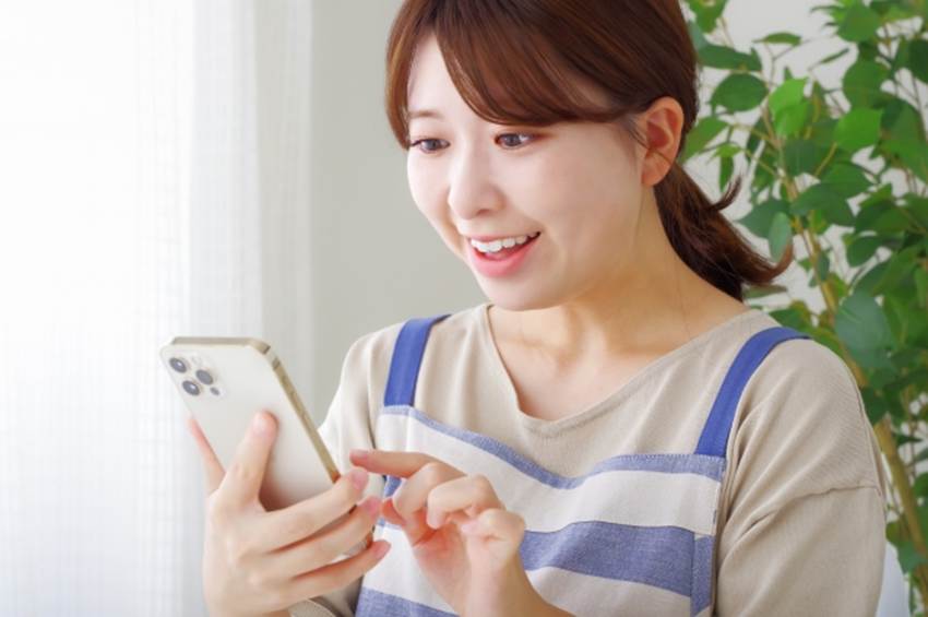 スマートフォンを差押しながら喜ぶ女性