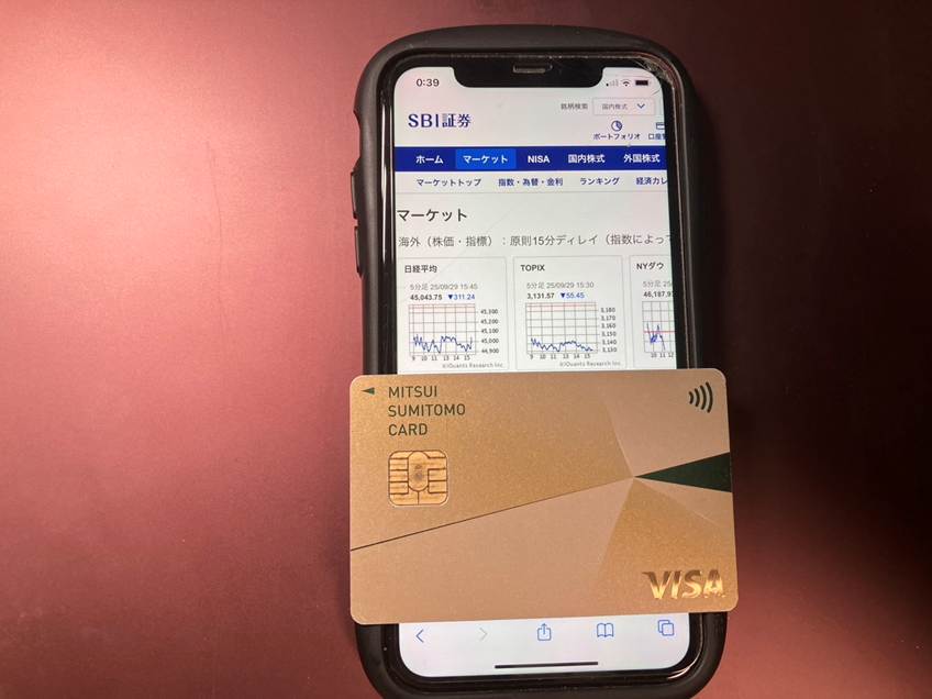 SBI証券のWebサイトが画面に表示されているスマートフォンと三井住友カード ゴールド（NL）
