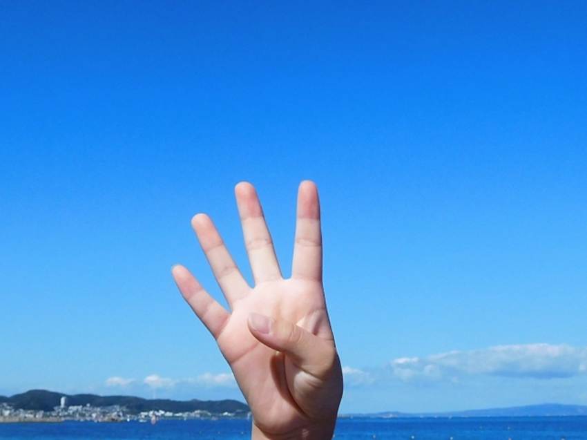 青空のなかで立てる4本の指