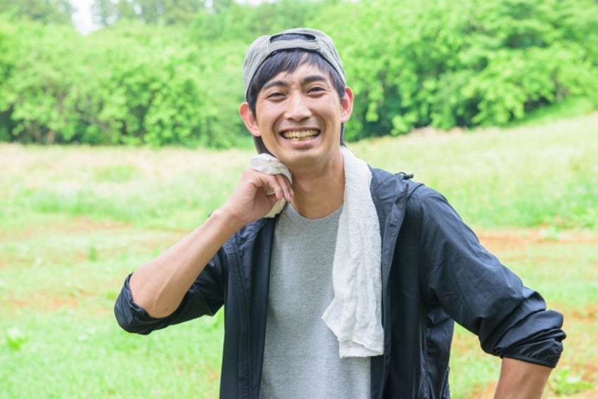 タオルで汗を拭く男性