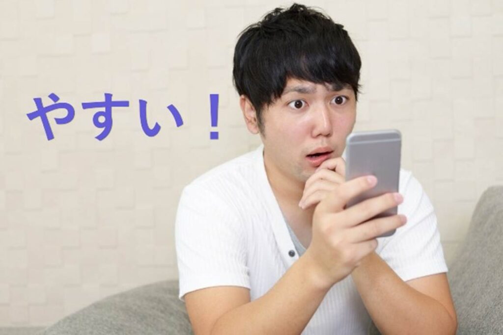 スマートフォンの画面を見て、価格に驚く男性