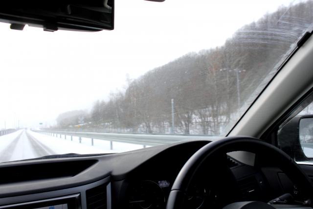 豪雪地帯を走る車の車内から見た景色