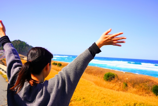 海に向かって手を広げる女性