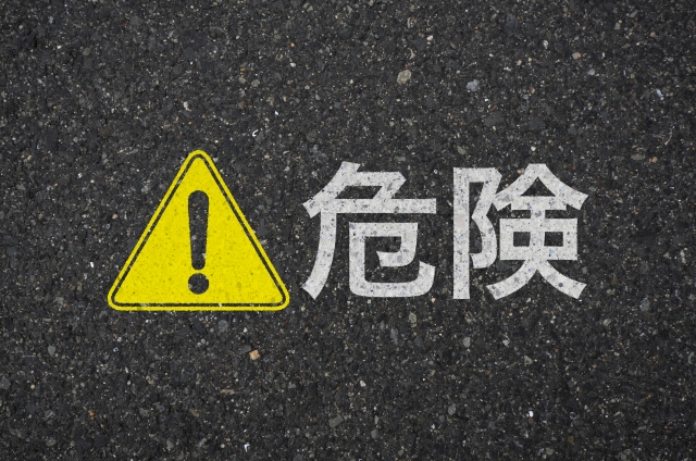 アスファルトに書かれている「危険」という言葉とマーク